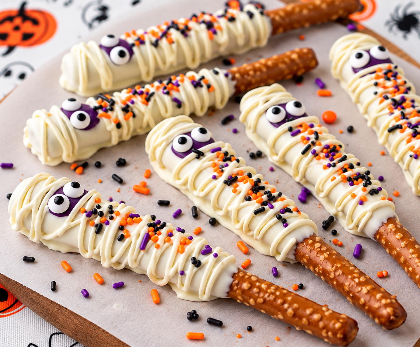 White chocolate-dipped pretzel rods with mummy drizzle & candy eyes
