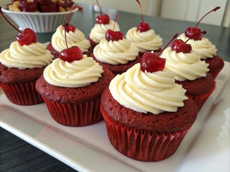 Red velvet cupcakes with buttercream and cherries